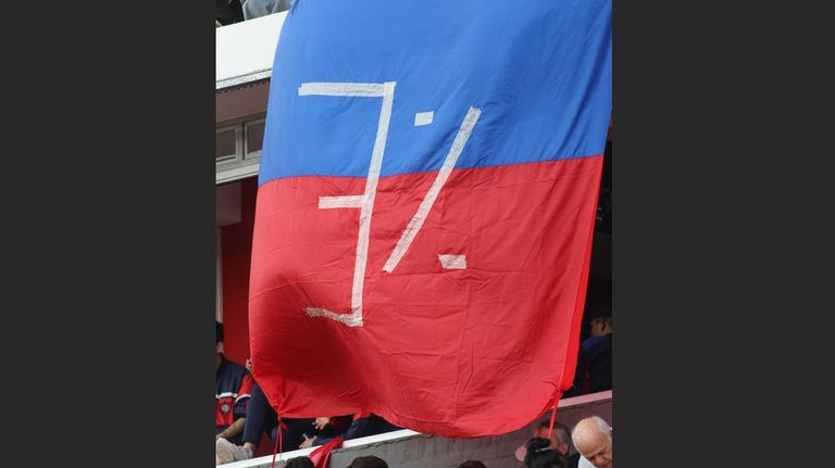 La bandera en las plateas del Ciclón ironizando con el 3% de las presuntas coimas a Karina Milei.