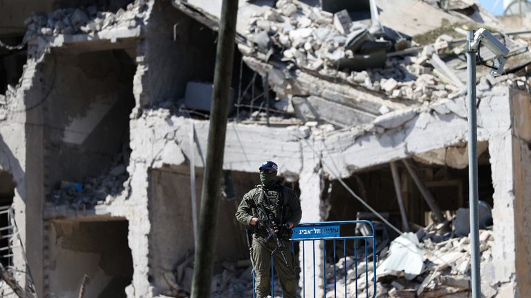 Un soldado custodia un edificio en Tel Aviv alcanzado por un misil israelí.