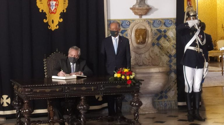 Alberto Fernández, firmando el libro de honor en el Palacio de Belém, junto al presidente Marcelo Rebelo de Sousa.
