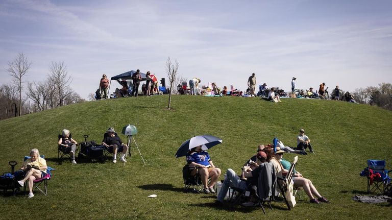 Un visitante mira a través de binoculares durante un evento de observación de eclipse en Bloomington, Indiana, EE. UU