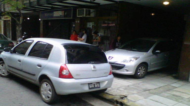 Auto estacionado bloqueando un garage y una rampa para discapacitados 20240312