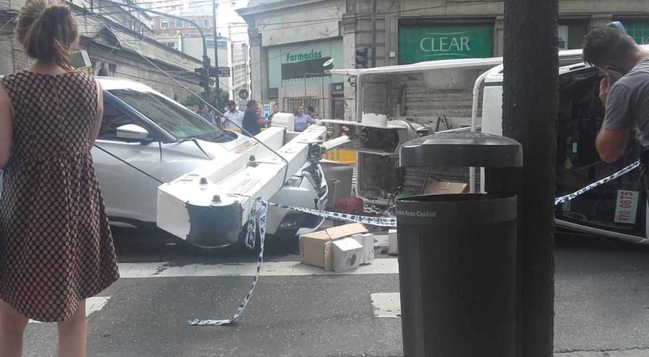 Una grúa se enredo entre los cables, volcó y aplastó un auto en pleno callao