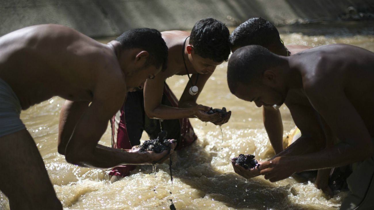 Los venezolanos buscan oro en un río contaminado para comprar comida